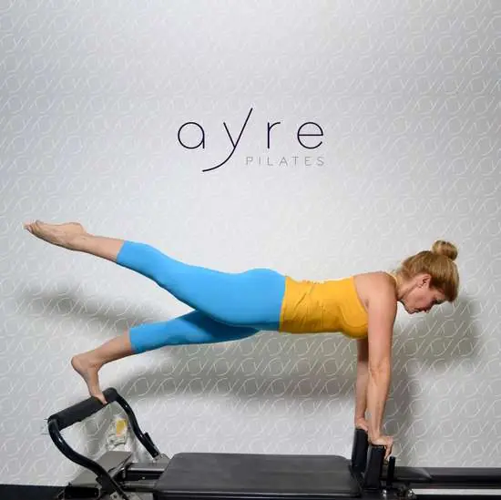 Ejercicio de plancha lateral en Pilates Reformer, Ayre Pilates